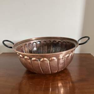 A Large Repousse Copper Bowl with Iron Handles