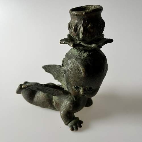 A Pair of Bronze Cherub Candlesticks with Green Glass Eyes image-2