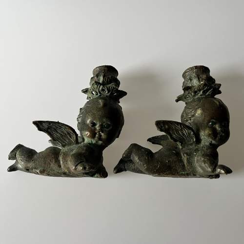 A Pair of Bronze Cherub Candlesticks with Green Glass Eyes image-3